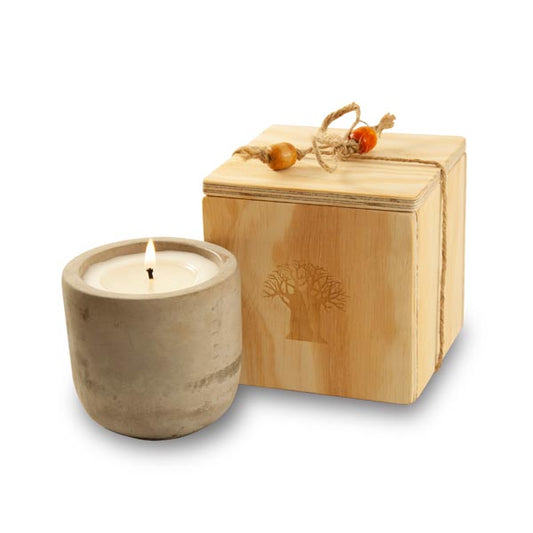 candle in raw cement holder packed in wooden box